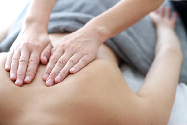 A massage therapist works on a patient's back.