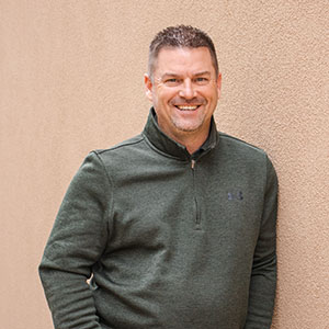 James Shrum poses against an adobe wall.