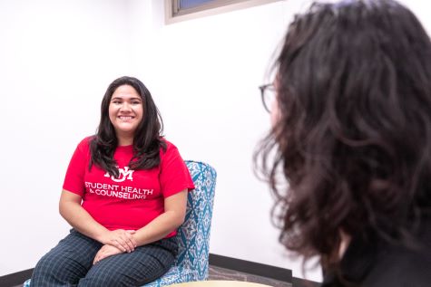 A student is sitting in a counseling session and smiling.