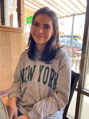 Lianna Maldonado is wearing a New York T-shirt and smiling for the camera.