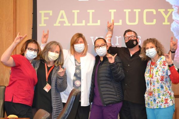 A group of SHAC clinical staff members pose against "Fall Lucy Awards" background.