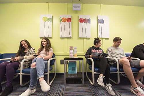 Four students wait for their appointments in the SHAC Reception Area.